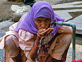 Rajasthani woman drinking at water tap